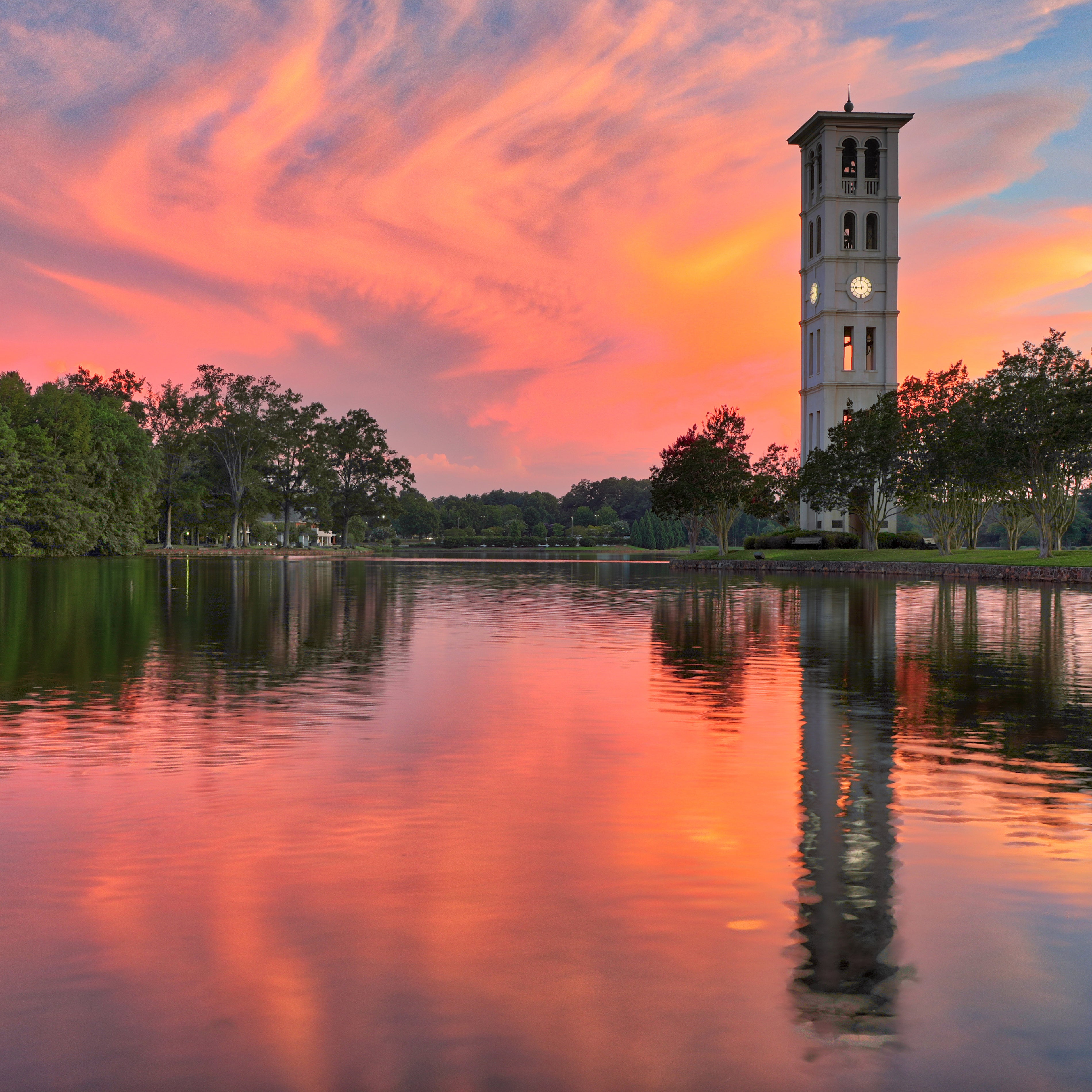 Red sunset and iconic Furman University tower with lake reflection