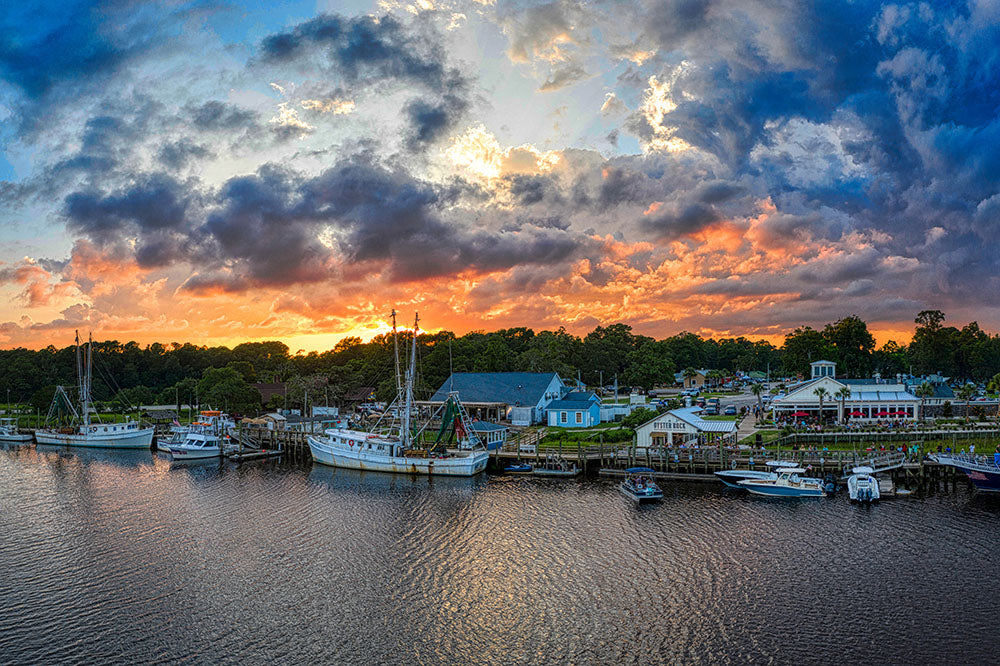 Photograph of shrimp boats in Calabash, NC with sun setting in the background