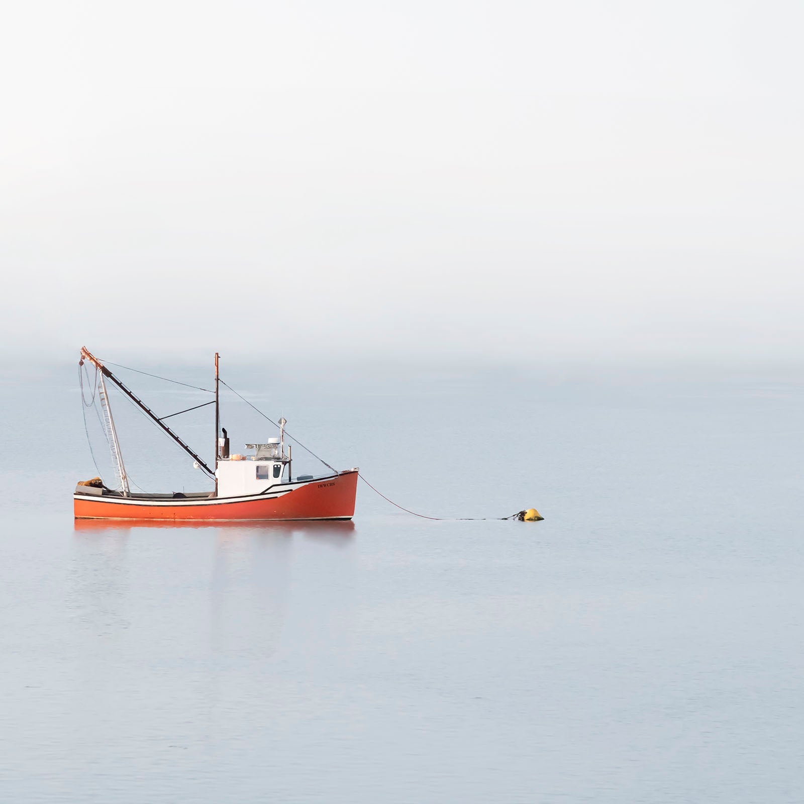 A red boat by itself on the ocean in Lubec, Maine